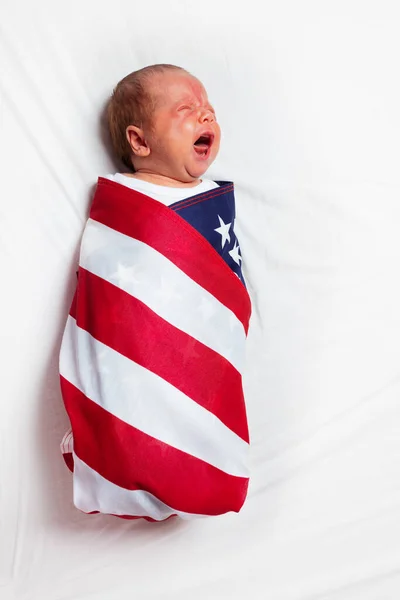 Pequeno bebê chorando envolto na bandeira dos EUA — Fotografia de Stock