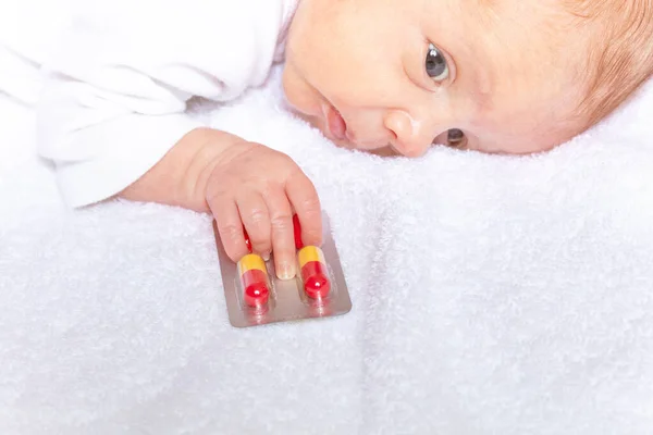 Paquet de médicaments pilules dans la main du petit bébé — Photo
