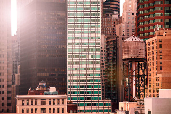 New York water tower on the roof with modern skyscraper buildings on background, NY, USA