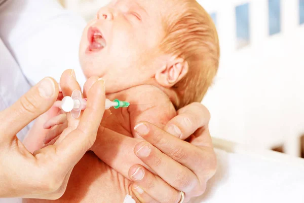 Nurse in a hospital hold syringe near baby infant — ストック写真