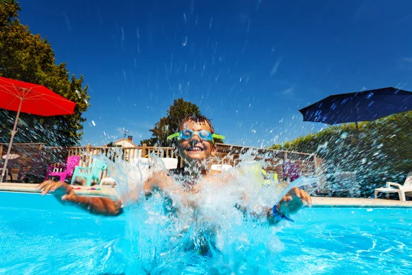 Garçon éclaboussure saut dans l 'piscine portant googles — Photo