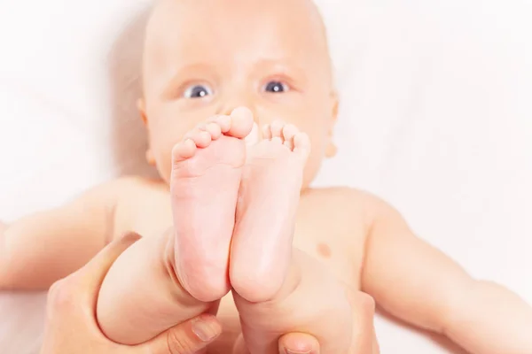 Close-up of baby feet hold by mother, face on back — Stockfoto