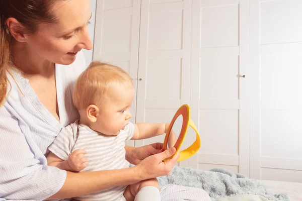 Mother and infant baby look at a mirror together — Stock Photo, Image