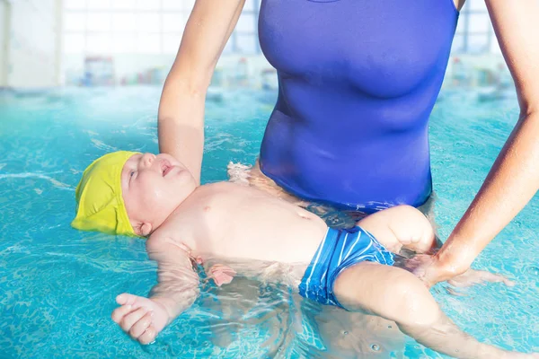 Little baby infant learn to float on back in pool — Stockfoto