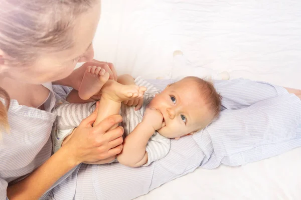 Mother play with little cute baby boy on her knees — ストック写真