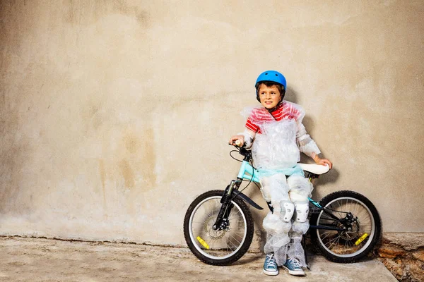 Boy with bicycle in overprotecting bubble wrap — Stock Fotó