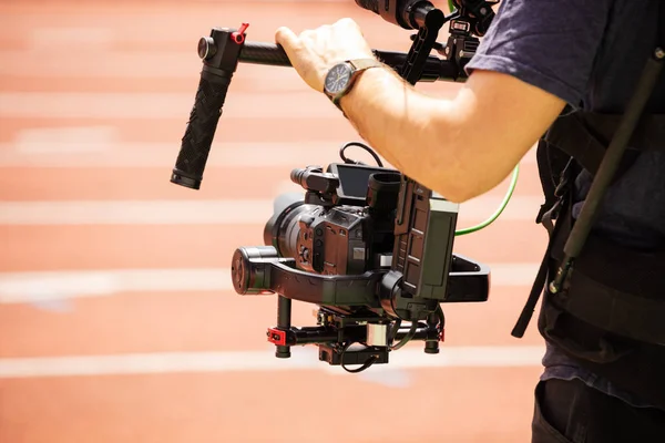 Hands and camera close-up of cameraman on stadium