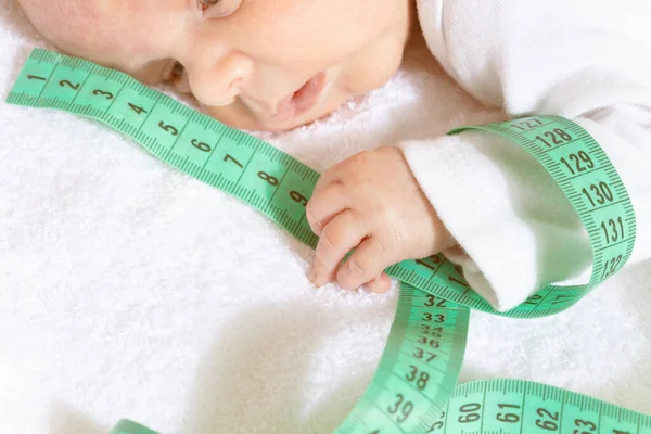 Cute baby infant boy hold green centimeter in hand — ストック写真