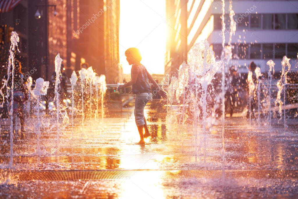 Happy boy run on fountain water Philadelphia city