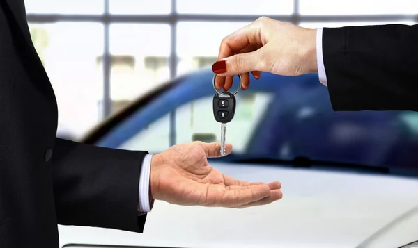 Car key handover at showroom — Stock Photo, Image