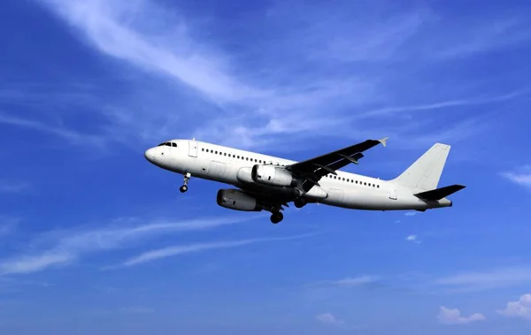 Avião de passageiros descolar sob céu azul nublado — Fotografia de Stock