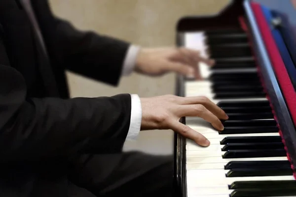 Mannen i svart kostym spela piano — Stockfoto