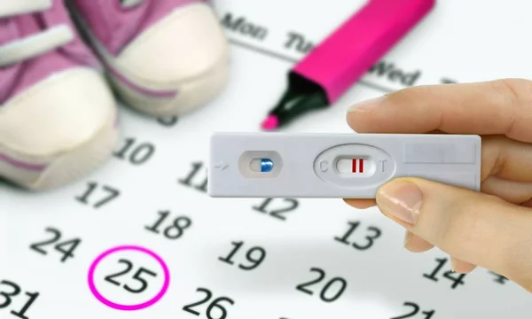 テストを持つ女性の手が陽性の妊娠検査のキットします — ストック写真