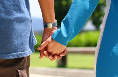 Mutlu çift el ele tutuşuyor.