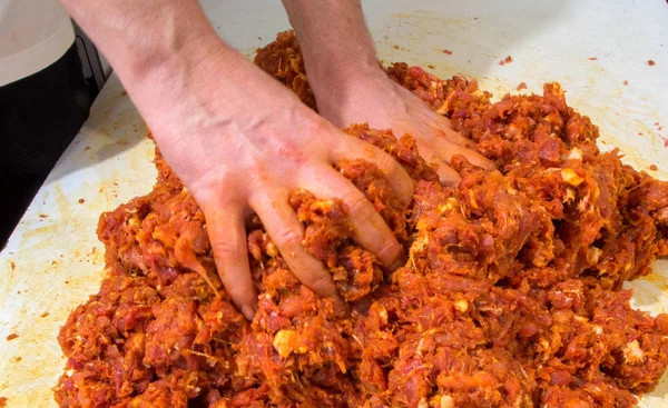 Руки змішують м'ясо з ковбасою — стокове фото