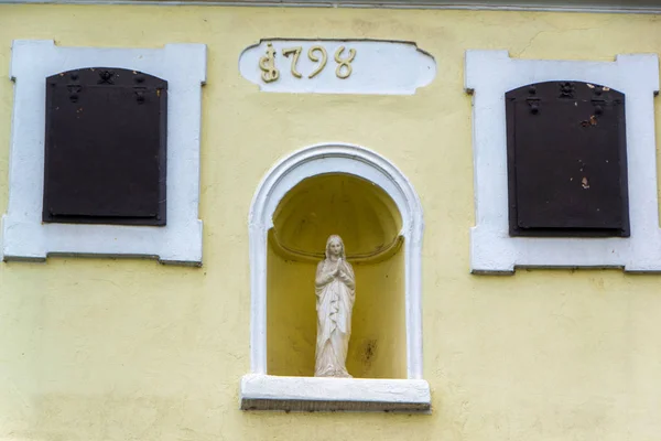 Skulptur und zwei Fenster am alten Haus — Stockfoto