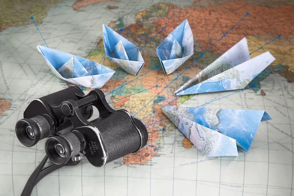 Travel concept. Paper ships and airplanes with binoculars on a map