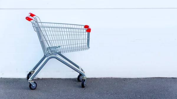 Lebensmittelkorb - vor dem Hintergrund alter weißer Wände, steht auf dem Bürgersteig in der Nähe des Gebäudes. — Stockfoto