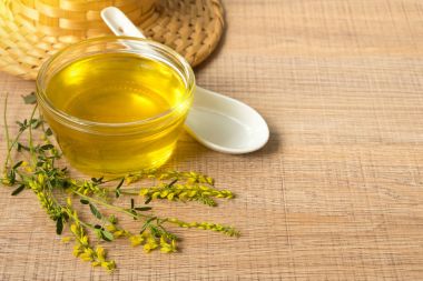 Cam fincan bal ve kır çiçekleri ile ahşap bir masa üzerinde bir sarı yonca ile.