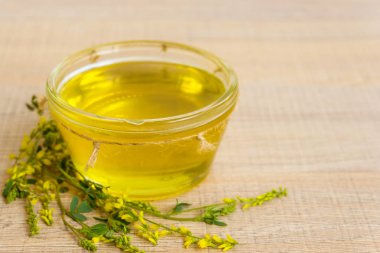 Cam fincan bal ve kır çiçekleri ile ahşap bir masa üzerinde bir sarı yonca ile.