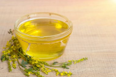 Cam fincan bal ve kır çiçekleri ile ahşap bir masa üzerinde bir sarı yonca ile.