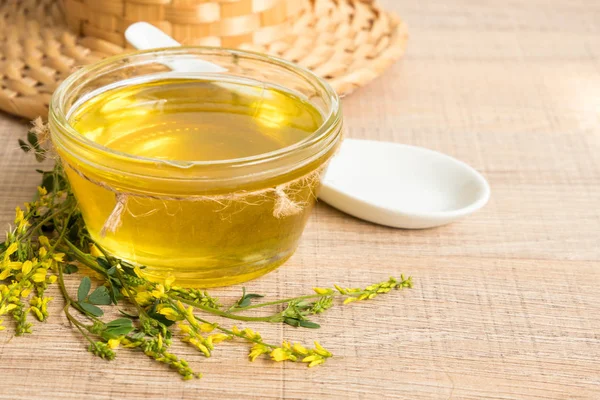 Cam fincan bal ve kır çiçekleri ile ahşap bir masa üzerinde bir sarı yonca ile.