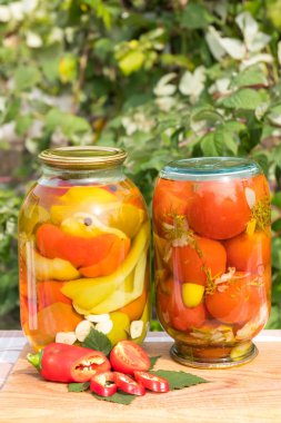 Cam şişe biber bezelye bir ahşap tahta üzerinde. Biber taze kesilmiş. Kış için ev ödevi.