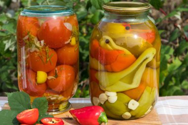 Bankalar konserve domates ve biber yağı ile. Bahçe arka plan üzerinde.