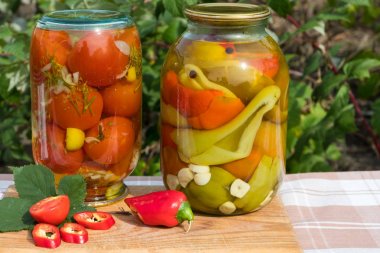 Bankalar konserve domates ve biber yağı ile. Bahçe arka plan üzerinde.