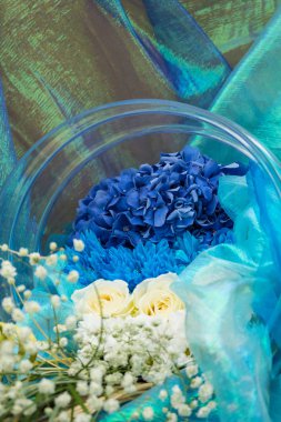 Mavi ve yeşil çiçekler su cam kavanozda sular altında. su damlaları, hava kabarcıkları.