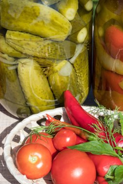 kavanoz korunmuş sebze, domates, biber. Ahşap bir masaya Bahçe arka planı.