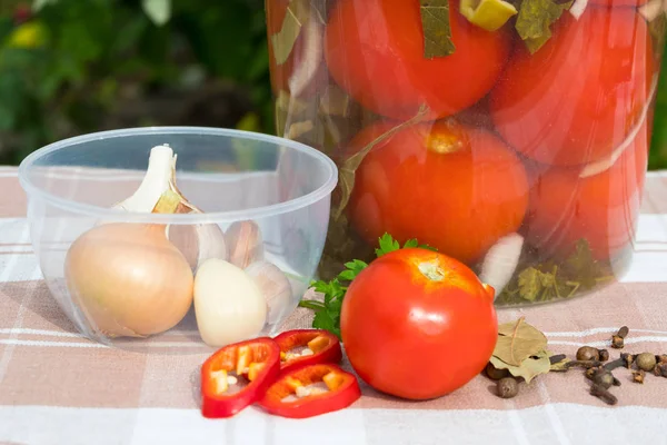 Пластикова бочка з солоними помідорами. Продукти для рецепта. Перець, цибуля, часник, спеції. На тлі сільської скатертини . — стокове фото