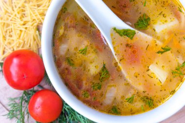 Domates çorbası erişte beyaz. Patates, dereotu, baharatlar. Ahşap bir gemide.