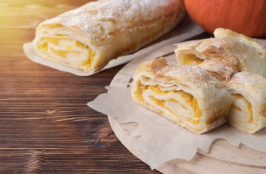 Kabak pasta bir somun şeklinde. Ahşap bir masaya. Bir yaprak şeklinde pişirme için kağıt. Kabak, pudra şekeri. Sonbahar, kutlama.