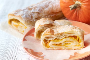 Kabak pasta bir rulo şeklinde. Ahşap bir masaya. Pudra şekeri. Yaprak peçete. Sonbahar.