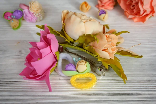 Blommor av Foamiran. Hår ornament gummiband på ett träbord. I retrostil. — Stockfoto