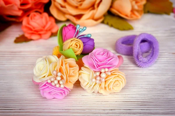 Blüten aus Schaumstoff. Haarschmuck Gummibänder auf einem Holztisch. im Retro-Stil. — Stockfoto