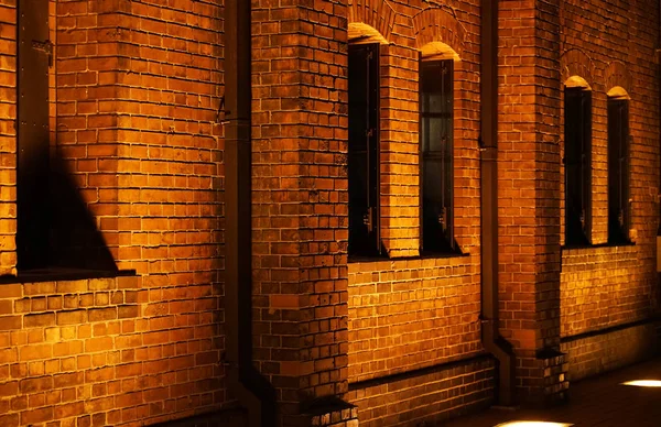 Widok Nocy Budynku Cegły Ściany Świecącej Pomarańczowe Światło — Zdjęcie stockowe