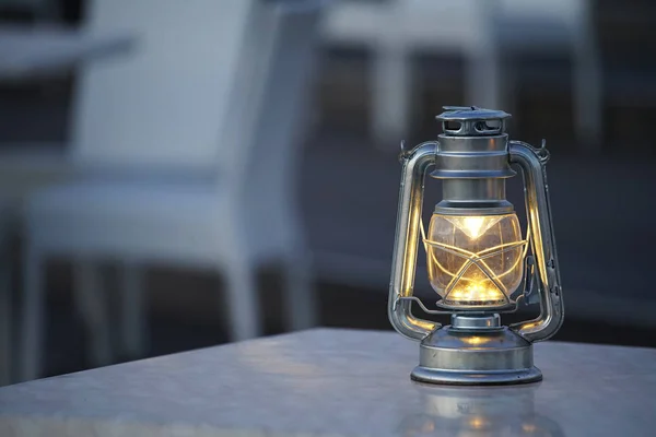 Gece bahçesinin masasına konan lamba.                               