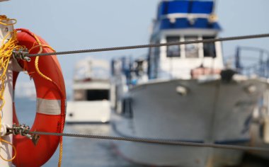 Bir gemi sahnesi ve halka şamandırası iyi olan limanda demirliyor.