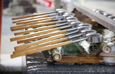 Japonya 'daki Shinto türbesinin girişinde suyu olan bir ağız ve eli temizleyen yer.                               