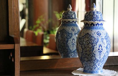 Evin aynası önünde sergilenen mavi porselenin süsü.