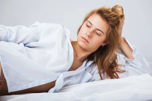 Mooie jonge vrouw in een witte mannen shirt — Stockfoto