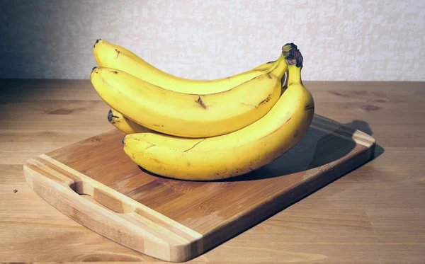 Bananenbündel auf einem Brett Stockbild