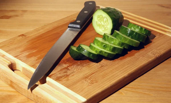 A cut cucumber and a knife Royalty Free Stock Photos