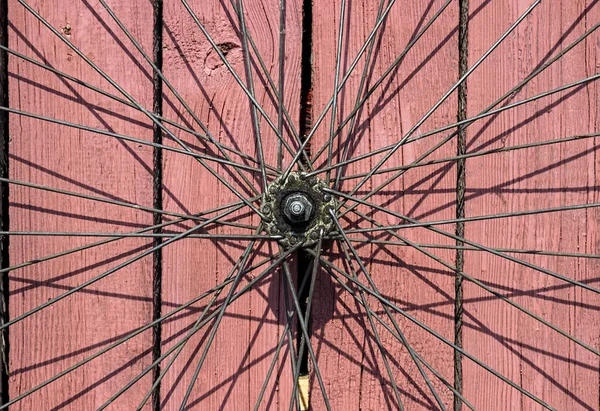 Vintage bicycle wheel on the old red wooden background. — Stock Photo, Image