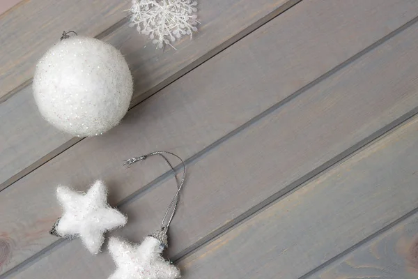 Adornos navideños en blanco sobre fondo de madera gris claro . —  Fotos de Stock