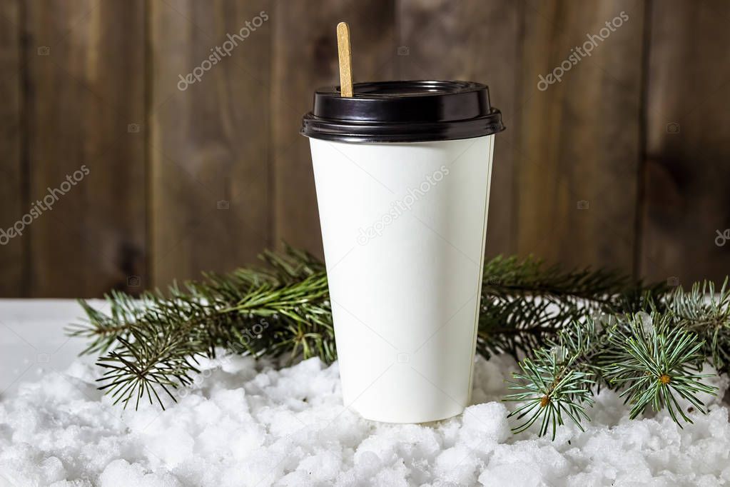 Paper cup of coffee in the snow.