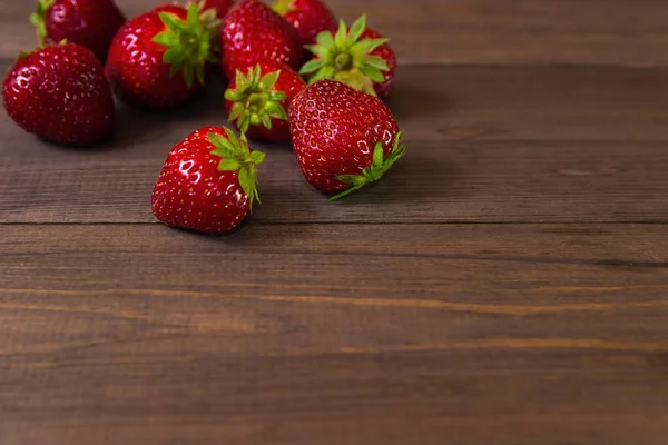 Koyu ahşap arka plan üzerinde çilek.