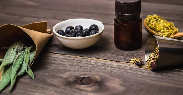 Viele verschiedene Heilkräuter auf dunklem Holzgrund. Homöopathisch — Stockfoto